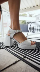 Sandalias plateadas con plataforma y taco ancho, tira delantera y tobillera con hebilla.