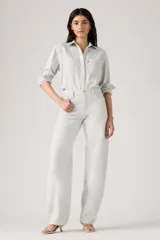 Pantalón de jean estilo baggy con corte barrel, tiro alto y pierna ancha. Presenta un tono gris claro lavado, con costuras reforzadas y diseño de cinco bolsillos.