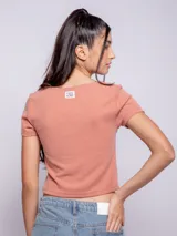 Remera color salmón elastizada de manga corta y cuello redondo.