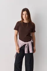 Remera blanca de manga corta y cuello redondo, con calce ajustado al cuerpo y diseño liso y minimalista.