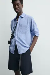 Bermuda de hombre color azul marino, de corte relajado (relaxed fit), confeccionada en tejido con textura. Presenta bolsillos frontales y bolsillos traseros de vivo, con cierre frontal de cremallera y botón.