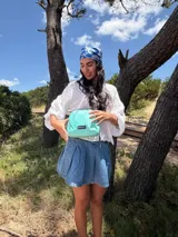 Bandolera pequeña de diseño moderno, confeccionada en tafeta liviana y resistente. Cuenta con cierre superior, correa ancha ajustable y logo frontal de la marca.