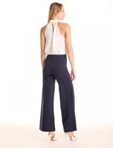 Pantalón palazzo azul marino de tiro alto, confeccionado en tejido elastizado. Presenta una cintura lisa y costuras verticales pronunciadas a lo largo de cada pierna. El corte es amplio desde la cadera hasta el ruedo, con una caída elegante.