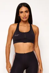 Top deportivo negro con cierre frontal, espalda cruzada y logo estampado en el pecho. Cuenta con abertura interna para copas removibles.