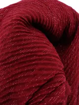 Bufanda rectangular negra con textura de tejido arrugado y detalles de hilos plateados.