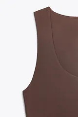 Camiseta blanca ajustada de poliamida con tirantes anchos y escote redondo.