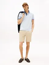 Chomba celeste de algodón elástico con cuello y mangas con ribeteado azul marino. Logo de Tommy Hilfiger bordado en el pecho.