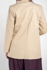 Blazer de algodón peinado, color beige, de calce al cuerpo con solapas clásicas y mangas largas.