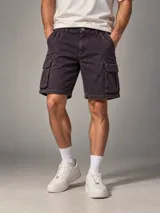 Bermuda cargo de jean con efecto óxido, color uva, bolsillos laterales con solapa y cierre de botón y cremallera.