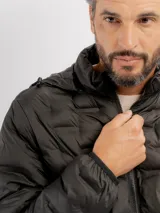 Campera puffer negra con diseño capitoneado, cierre frontal completo y capucha integrada.