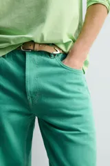 Jeans de mezclilla de corte recto, tiro medio, color verde vibrante con efecto lavado. Presenta cierre frontal con cremallera y botón, y cinco bolsillos.