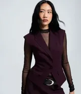 Chaleco femenino de sastrería con diseño estructurado tipo hourglass, solapa clásica, cierre frontal con dos botones y bolsillos con solapa. Cuenta con recortes que definen la cintura y forro interno.