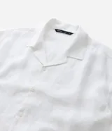 Camisa masculina blanca de lino, modelo boxy, con cuello bowling, manga corta y abotonado delantero.