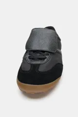 Championes deportivos de estilo minimalista, confeccionados en una combinación de materiales textiles y sintéticos con textura. Presentan una lengüeta superpuesta con cierre de gancho, cordones ocultos, punta redonda y suela plana de goma color caramelo.