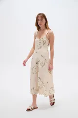 Vestido midi de viscosa color beige con estampado de hojas en tonos verdosos, de corte holgado, con tirantes finos regulables y escote cuadrado.