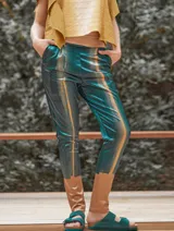 Pantalón de satén pintado a mano con diseño abstracto en tonos verde azulado y ocre.