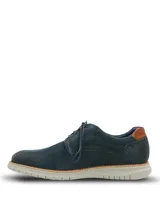 Zapato de estilo casual tipo derby, confeccionado en cuero azul marino con acabado gamuzado. Presenta detalles de costuras decorativas y perforaciones tipo brogue en los laterales, con un detalle en cuero color suela en el talón. Cuenta con cordones al tono y una suela de EVA flexible en color gris claro con tecnología de amortiguación.