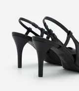 Zapato tipo slingback de color negro, confeccionado en poliuretano con acabado liso. Presenta una punta fina alargada, tacón fino y tira trasera con elástico para ajuste.