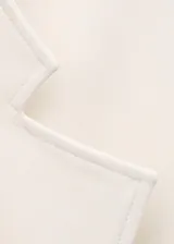 Chaqueta de mezcla de lana, poliéster y elastano color marfil, con solapas cruzadas, cuello alto y cinturón ajustable del mismo tejido. Cuenta con mangas largas y forro interior de viscosa.