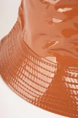 Gorro tipo bucket impermeable de acabado brillante, color negro, con costuras horizontales en el ala.