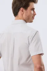 Camisa de manga corta con microcuadros en tonos celestes y blancos, calce slim, cuello con botones y bolsillo frontal con logo bordado.
