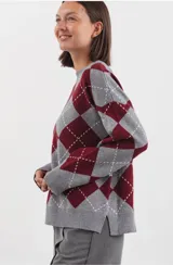 Sweater de punto con diseño de rombos estilo argyle en tonos gris y bordó. Presenta cuello redondo y terminaciones acanaladas en puños y cintura.