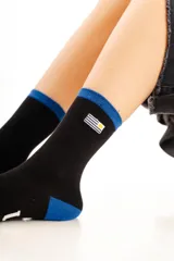 Medias de caña media color negro con detalles en azul en el puño y el talón. Presentan un pequeño bordado de la bandera de Uruguay en el lateral.