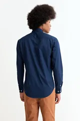 Camisa de manga larga en color beige, confeccionada en algodón, con cuello clásico y cierre frontal de botones.