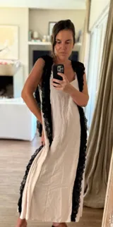 Vestido largo de estilo lencero color crema, con puntillas negras aplicadas verticalmente en el frente y la espalda.