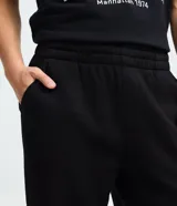 Pantalón jogger de algodón con felpa, color beige, con cintura elástica, cordón ajustable, bolsillos laterales y puños elásticos en los tobillos.