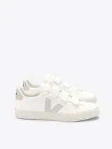 Championes Veja modelo Recife, de diseño minimalista en color blanco con detalles en gris claro. Presentan cierre mediante tres tiras de velcro, logo lateral en forma de V y suela de caucho.