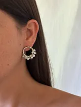 Aro plateado de 2 cm de diámetro con cuentas de vidrio facetadas colgantes en tonos blancos y grises.