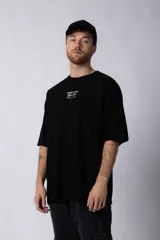 Remera de corte oversize color negro, con cuello redondo y mangas cortas. Presenta una estampa pequeña en el centro del pecho con la frase 'Fresh from the vine' en tipografía blanca.