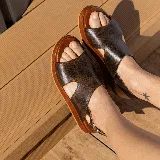 Sandalias de cuero color blanco con textura tipo reptil, plataforma marrón y hebilla metálica plateada.