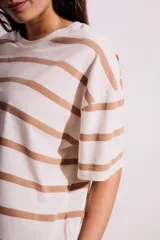 Remera de algodón color crudo con rayas horizontales color café, de corte oversize y mangas cortas.