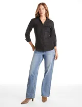 Camisa entallada de color negro con pechera estructurada mediante alforzas horizontales. Presenta cuello con solapa, escote en V, cierre frontal con botones y mangas tres cuartos con puños anchos rebatibles.