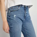 Pantalón de jean azul de corte slim, tiro alto y largo al tobillo.