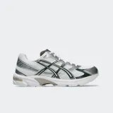 Championes Asics modelo Gel 1130 de estilo retro, color blanco con detalles en plateado y verde oscuro. Incorporan tecnología GEL en el talón para mayor amortiguación.