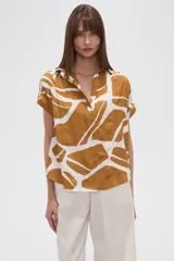 Blusa holgada de viscosa con cuello en V y manga corta. Presenta un estampado abstracto en tonos marrón mostaza y blanco.