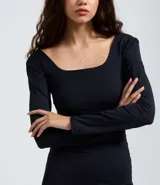 Vestido midi de microfibra color marrón, con escote cuadrado, manga larga y corte ajustado al cuerpo. Presenta una abertura lateral en la falda.