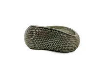 Brazalete rígido y ancho de metal plateado con textura en relieve que imita un patrón de escamas.