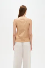 Top de viscosa color blanco con tirantes finos, cuello a la base y cierre frontal con botones. Presenta bolsillos appliqués con solapa en la parte inferior y diseño al cuerpo.