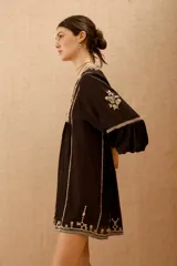 Vestido corto de viscosa crepe color negro, con escote en V, mangas largas abullonadas y detalles de bordado en hilo a contratono en el escote, mangas y ruedo.