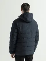 Campera acolchada con capucha integrada y cuello alto. Presenta cierre frontal completo, bolsillos laterales con cierre y puños con terminaciones elásticas para mayor protección contra el frío.