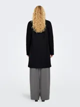 Blazer largo de corte recto y estilo minimalista, con cuello solapa, cierre frontal de dos botones y dos bolsillos frontales de parche.