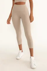 Calzas capri color beige de tiro alto, confeccionadas en tejido de alta densidad que se ajusta a la cintura y estiliza las piernas y los glúteos.