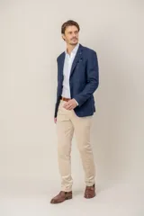 Saco de vestir con diseño de espiga en color marrón, confeccionado en mezcla de lana y seda. Presenta solapas clásicas, cierre frontal de dos botones y bolsillos laterales con solapa.