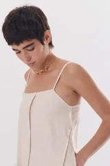 Gargantilla dorada con cadena fina y dije rígido con forma de onda.