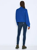 Sweater tejido de punto grueso con cuello alto, mangas largas raglán y puños acanalados. Presenta un diseño de calce holgado y textura acanalada.