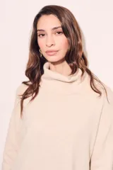 Sweater negro de cuello alto con tajos laterales y detalle de línea plateada en puños y ruedo.